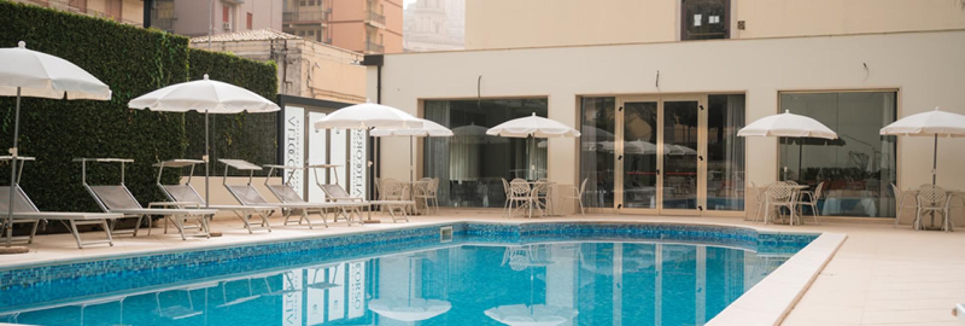 Hotel Principe D'Aragona's pool with loungers and umbrellas.