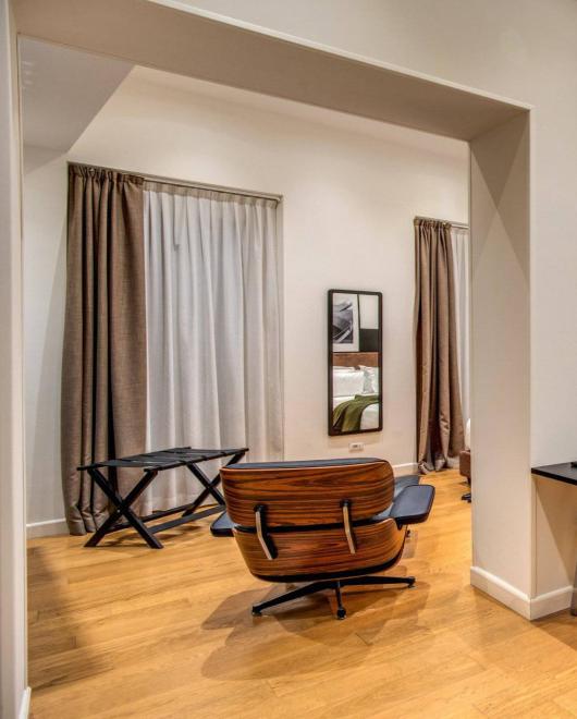 Modern living room with chair, desk, and adjacent bathroom.