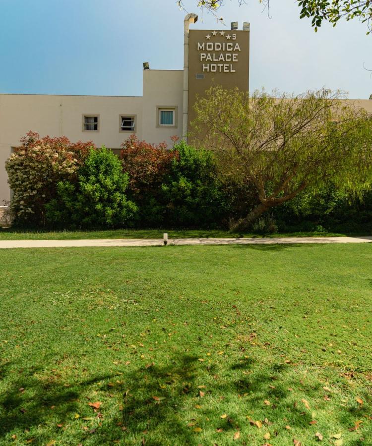 Hotel moderno con giardino curato e rigogliosa vegetazione.