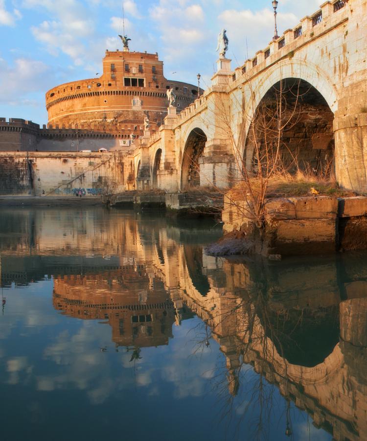 Castel Sant'Angelo and Ponte Sant'Angelo reflected in the Tiber at sunset.